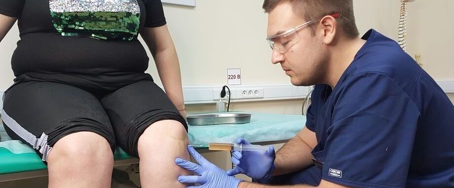 Az ortopéd orvos intraartikuláris injekciót ad a térdízületbe osteoarthritis esetén