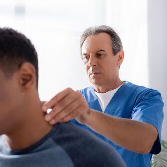 Az orvos diagnosztikai vizsgálatot végez egy nyaki fájdalomban szenvedő betegen.